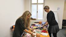 Prachatičtí dobrovolníci vybírají panenky a látky na jejich nové oblečky.
