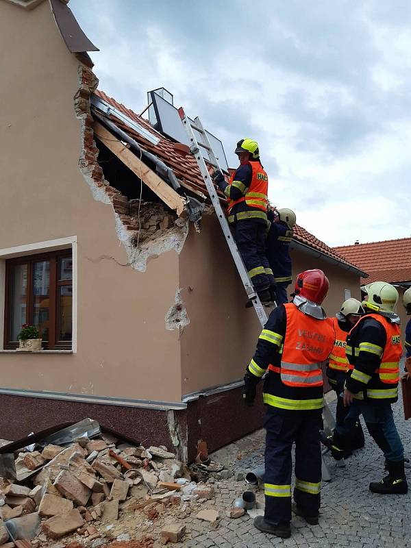 Vlachovobřezští hasiči likvidují následky nárazu kamionu do domu.