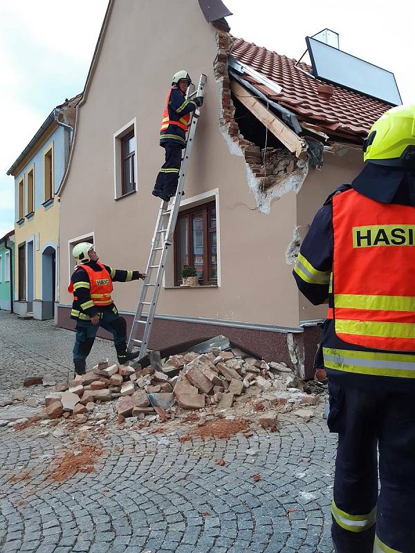 Vlachovobřezští hasiči likvidují následky nárazu kamionu do domu.