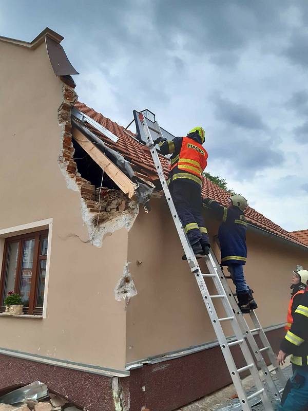 Vlachovobřezští hasiči likvidují následky nárazu kamionu do domu.