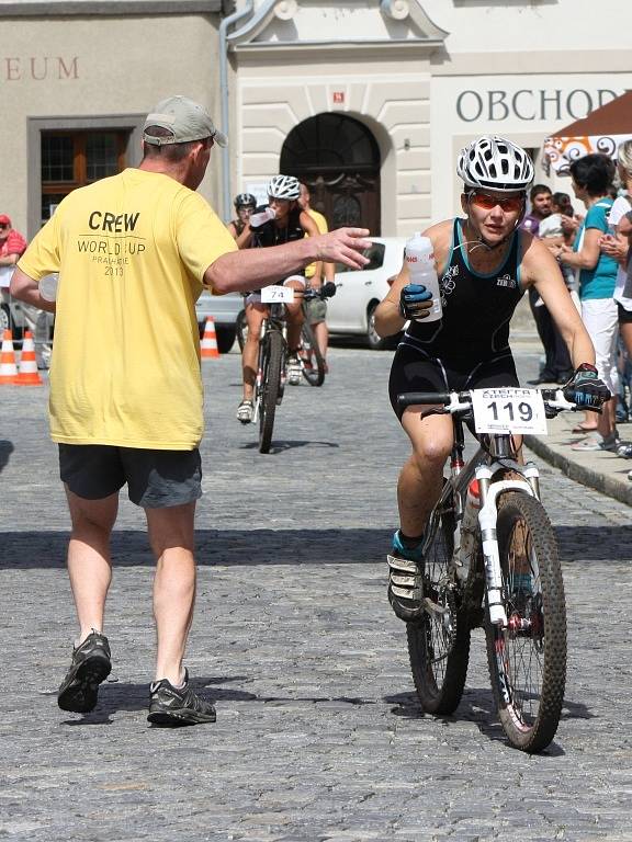 Hlavní závod se dostal na Velké náměstí v Prachaticích. Závodníci vjíždějí do druhého kola cyklistické části hlavního závodu.