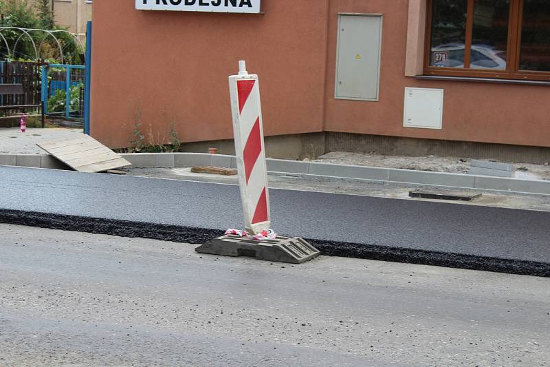 Na silnici v Plzeňské ulici se začal pokládat nový asfalt.