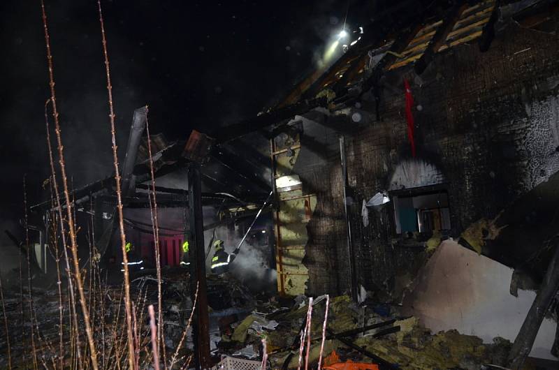 Požár osobního vozidla, garážového přístřešku a rodinného domu v Červeném Újezdu v okrese Praha-západ.