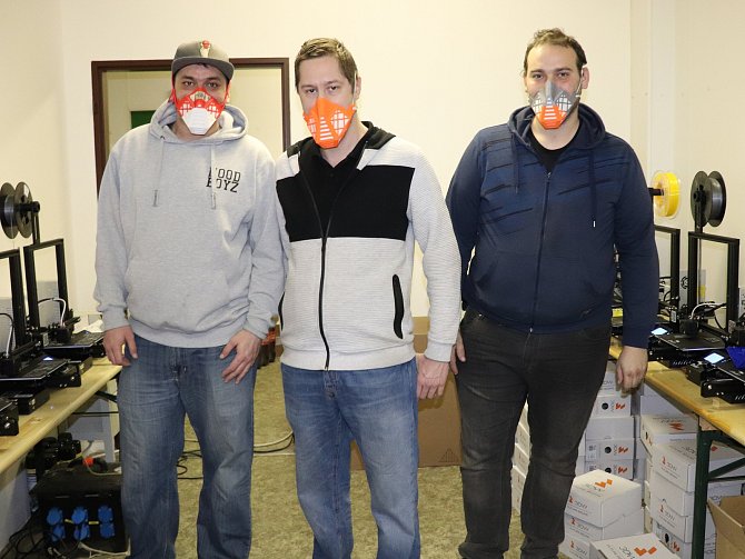 Dobrovolníci z Králova Dvora tisknou ochranné masky, Petr Novák uprostřed.