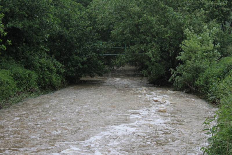 Rozbouřený Stroupínský potok zablokoval ve Hředlích komunikaci směrem na Točník.