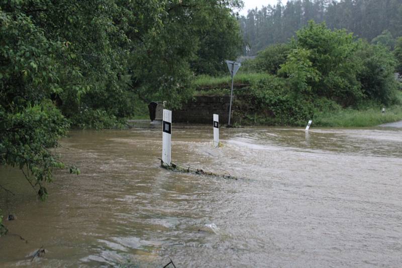 Rozbouřený Stroupínský potok zablokoval ve Hředlích komunikaci směrem na Točník.