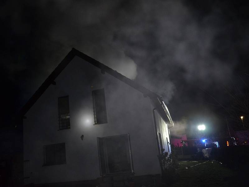 Požár osobního vozidla, garážového přístřešku a rodinného domu v Červeném Újezdu v okrese Praha-západ.