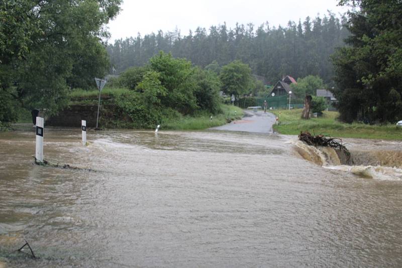 Rozbouřený Stroupínský potok zablokoval ve Hředlích komunikaci směrem na Točník.