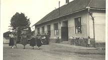 Neumětelský hostinec po přestavbě z roku 1935. Vyfoceno kolem roku 1950, kdy se tu pořádaly taneční námluvy. Ženy na snímku jsou svazačky, které zřejmě zpívaly častušky. Dívka stojící na rohu u bicyklů by měla být současná kronikářka Marie Malínská.