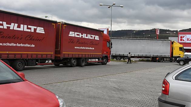 Kamiony parkující navzdory zákazům vjezdu pro nákladní automobily na parkovišti v nákupní zóně v Berouně (18. 11.) a autobus na parkovišti pro osobní auta před hypermarketem na pražském Zličíně (17. 11.).