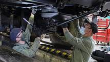 Mechanici kontrolují podvozek a motorovou část nákladního automobilu Tatra.