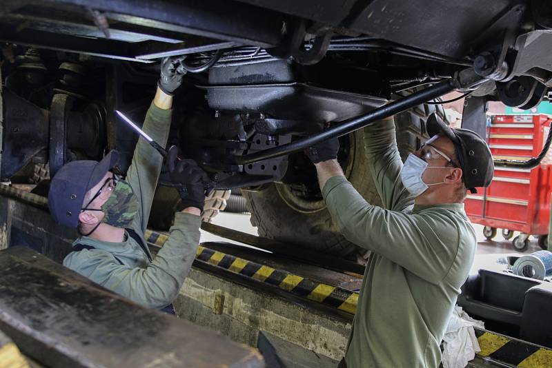 Mechanici kontrolují podvozek a motorovou část nákladního automobilu Tatra.