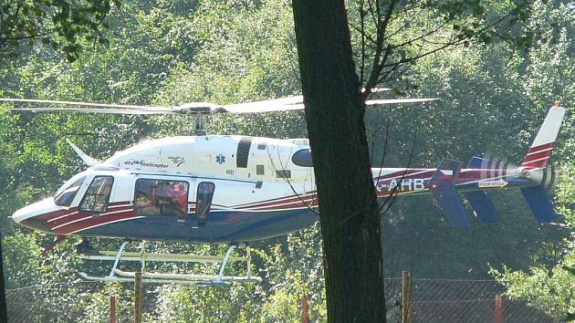 Vrtulník odlétá od tenisových kurtů se zachráněnou dívenkou.