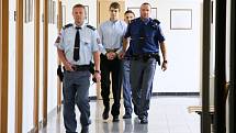 Eskorta vězeňské služby přivádí k soudu obžalovaného čtyřiadvacetiletého Lukáše Nováka. Měl zabít mačetou svého otčíma.