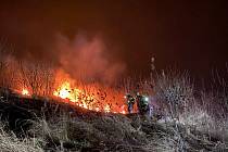 Požár suché trávy, křoví a náletových dřevin ve stráni v prostoru skládky v lokalitě Na Zájezdě ve Veltrusech.