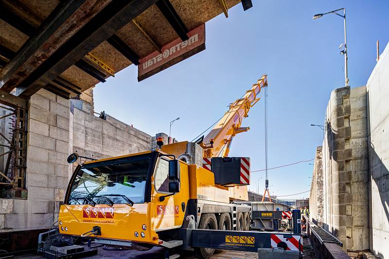 Usazování nových vrat do zdymadla v Hořínském plavebním kanálu u Mělníka. Montáž vrat probíhala pomocí autojeřábu, který byl umístěn na nákladní lodi a vrata zdvihal.