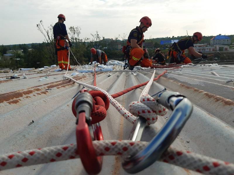Středočeští hasiči pomáhají na Moravě s rozebíráním plechů ze střech a stěn objektů.