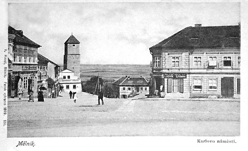 Pohled z mělnického Karlova náměstí na hostinec v roce 1899. V přilehlé vodárenské věži, která pochází ze středověku, byla zásobní nádrž městského vodovodu. Pod věží bylo ve středověku umístěno městské popraviště (stínadla), protože město mívalo trestní p