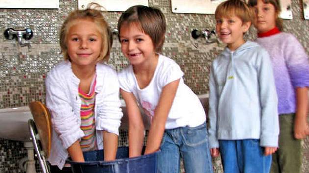 PRVŇÁČKOVÉ si před včerejším obědem vzorně myli ruce v dezinfekčním roztoku, který na všechny strávníky čeká před školní jídelnou, a utřeli si je jednorázovými papírovými ručníky. 