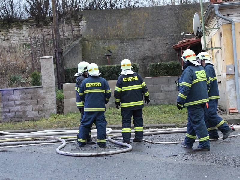 Podkrovní byt v domě na Okrouhlíku v noci vyhořel. Hasiči museli zachraňovat matku s dítětem oknem na terase.