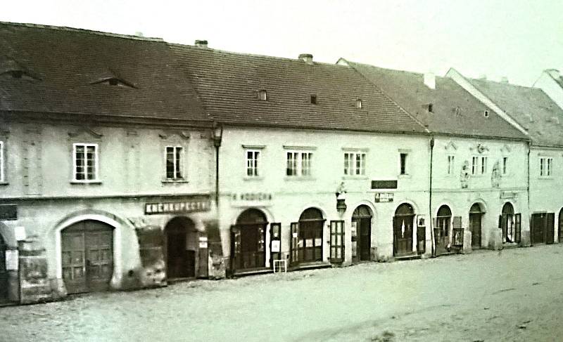 Západní strana náměstí Míru: vlevo barokní dům (nyní budova Komerční banky), druhý dům zleva je č.p. 27. Na fasádě byla umístěna socha sv. Jana Nepomuckého. Snímek z doby před rokem 1890. Před rokem 1870 bylo v přízemí čtyř domů průchozí podloubí.