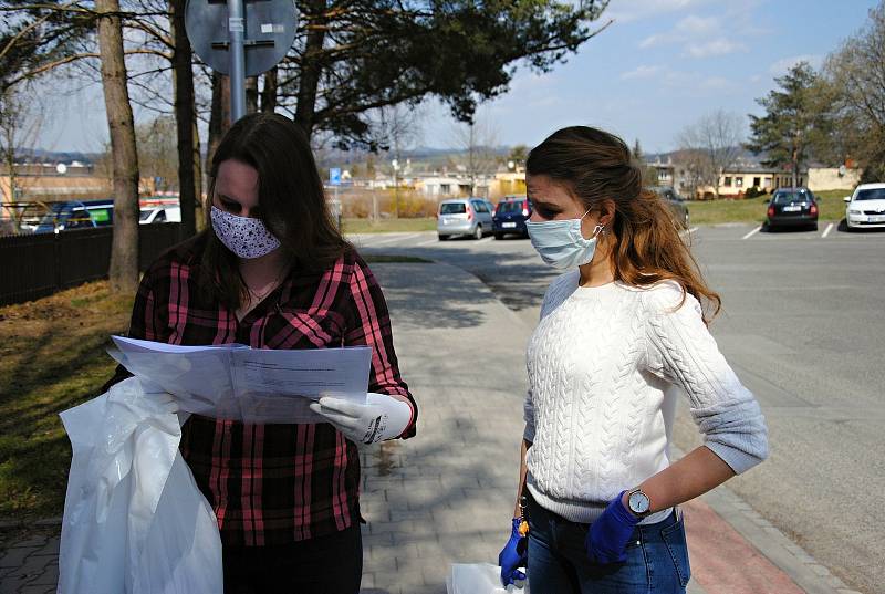 Studentky Eliška Skýpalová (v bílém svetru) a Karolína Knápková se během první vlny koronavirové epidemie zapojili ve Valašském Meziříčí do distribuce ochranných pomůcek seniorům.