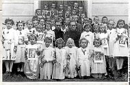 SVATÉ PŘIJÍMÁNÍ. První svaté přijímání v roce 1951. Na snímku s dětmi farář Jindřich Deneš.