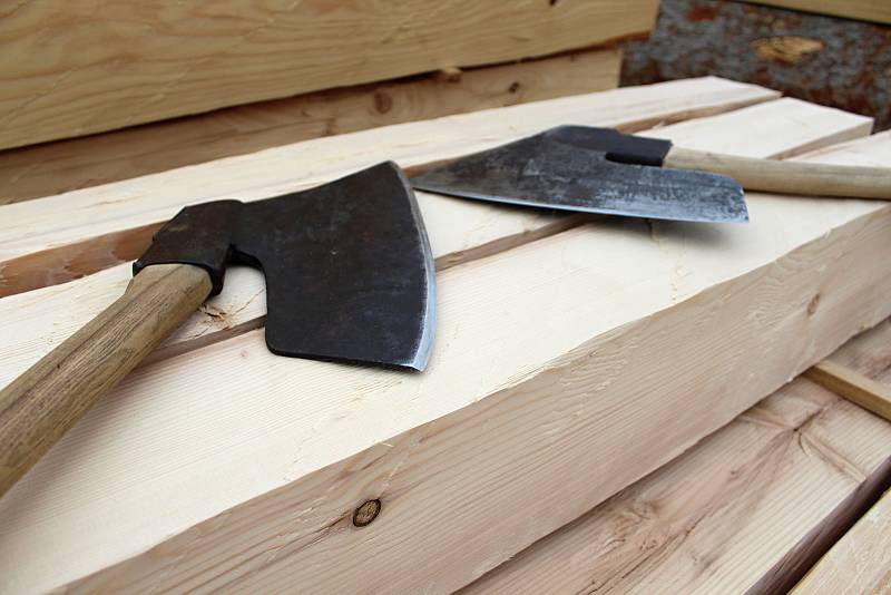 Řemeslníci zpracovávají na jaře 2018 stovky kubíků dřeva na stavbu kostela v Gutech. Trámy z jedlového dřeva se otesávají 3 kilogramy vážící sekerou zvanou širočina.
