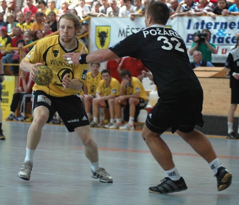 1. zápas finále Zubr extraligy v házené: Zubří - Karviná 25:27 (14:12). Zuberský hráč Ondřej Mika se probíjí přes karvinského pivota Romana Požárka.