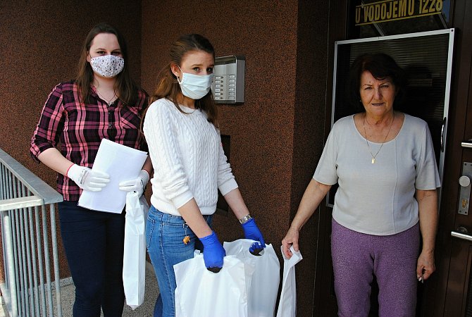 Studentky Eliška Skýpalová (v bílém svetru) a Karolína Knápková se během první vlny koronavirové epidemie zapojili ve Valašském Meziříčí do distribuce ochranných pomůcek seniorům.
