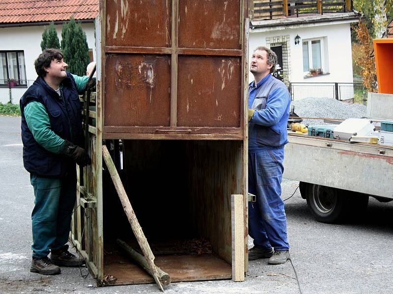 Řemeslníci Antonín Hajda (ve vestě) a Radek Machala (v modrém) z Ratiboře opravují v Oznici odchytovou klec na toulavého medvěda. Asistuje také starosta obce Oznice Martin Gerža (vlevo). Klec byla přivezena ze Slovenska z oblasti Malé Fatry.