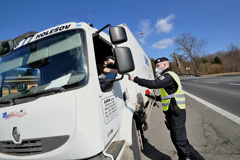 Policejní hlídka v souladu s nařízením vlády kontroluje v pondělí 1. března 2021 ve Valašských Příkazech řidiče mířící mimo okres Vsetín.