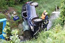 Záchranáři zasahují ve středu 28. června 2023 ráno u havárie osobního vozu Suzuki Grand Vitara do koryta potoka v Zubří. Řidička se zranila.