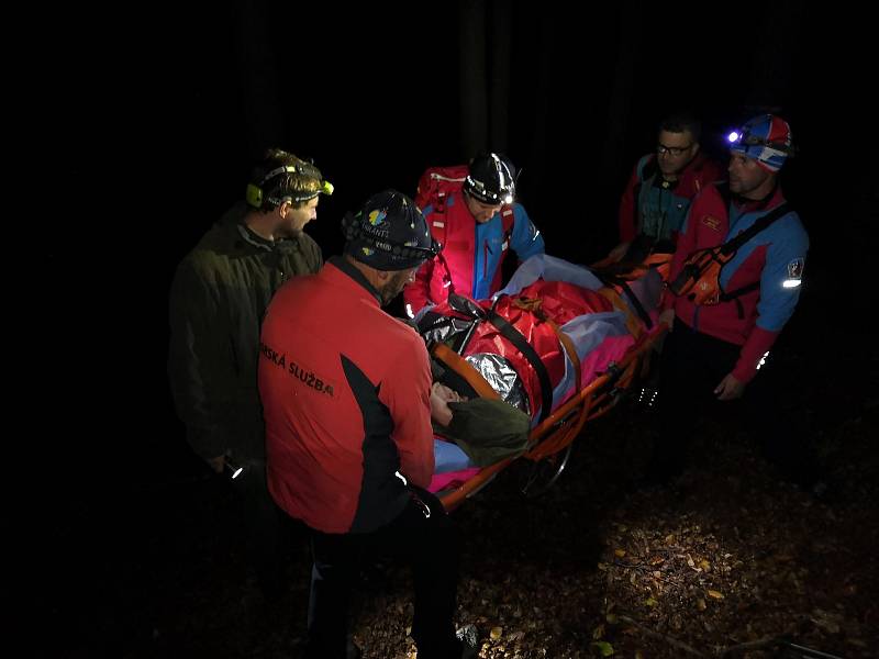 Horští záchranáři transportují ve čtvrtek 26. září 2019 těžkým terénem k sanitce myslivce, který se v lokalitě Čertův mlýn vážně zranil při pádu z posedu.
