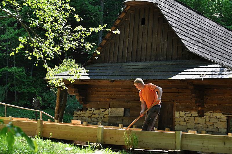 Pracovník Valašského muzea v přírodě v Rožnově pod Radhoštěm čistí nově zbudované dřevěné koryto náhonu, který přivádí vodu k objektu pily z Velkých Karlovic v areálu Mlýnské doliny; pondělí 18. května 2020.