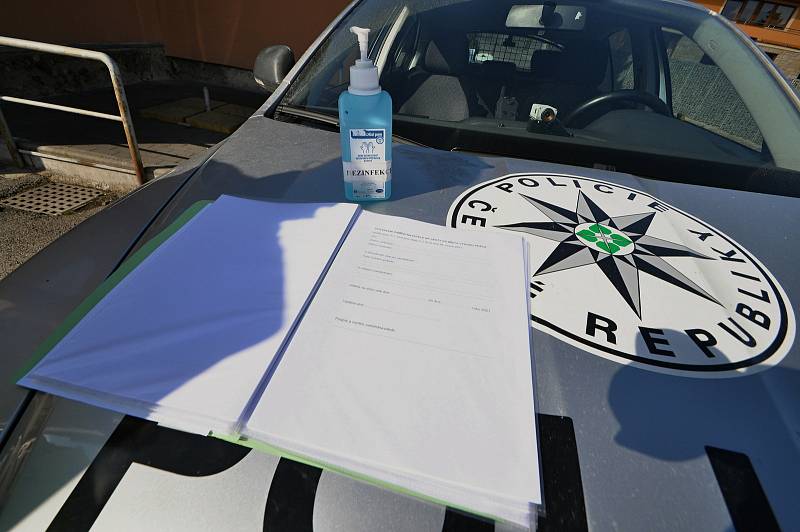 Policejní hlídka kontroluje v pondělí 1. března 2021 ve Valašských Příkazech řidiče mířící mimo okres Vsetín. Ve výbavě policistů nechybí dezinfekce, k dispozici mají i formuláře potřebné při cestách mimo okres, které mohou poskytnout motoristům.