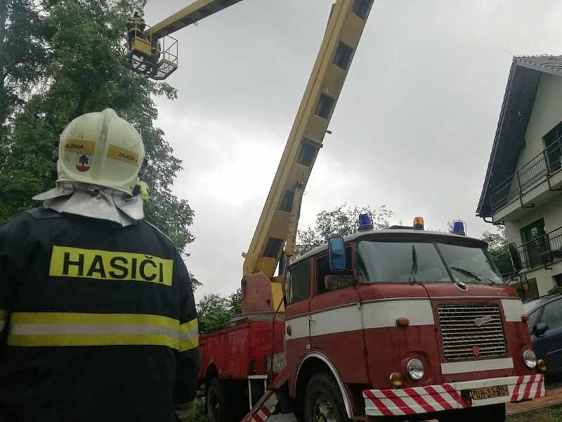 Dobrovolní hasiči z Jablůnky odstraňují v pátek 19. června 2020 strom hrozící pádem na obytný dům.
