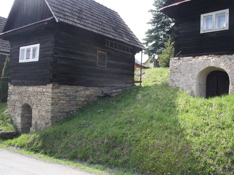 Soubor tří původních roubených valašských sklípků na kamenné podezdívce.