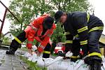Dobrovolní hasiči z Krhové připravují naplněné pytle s pískem, které budou v obci sloužit jako protipovodňové zábrany; Krhová, pátek 16. května 2014.