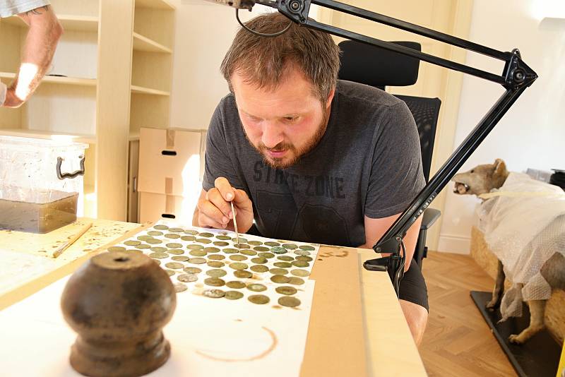 Archeolog Muzea regionu Valašsko Samuel Španihel zkoumá nález několika stovek stříbrných pražských grošů ze 14. století nalezených v lese v Ústí u Vsetína.