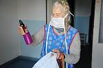Seniorka ve Valašském Meziříčí si prohlíží dezinfekci a další ochranné prostředky, které jí domů přinesli dobrovolníci z místního Dobrovolnického centra Adra. (4. dubna 2020)