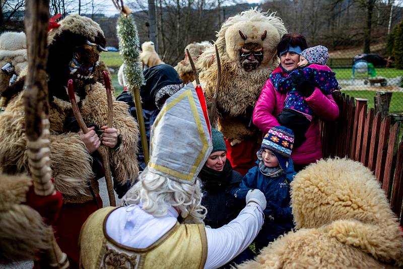 Muži v maskách čertů procházejí při oslavě svátku sv. Mikuláše, 4. prosince 2021 Valašskou Polankou na Vsetínsku.