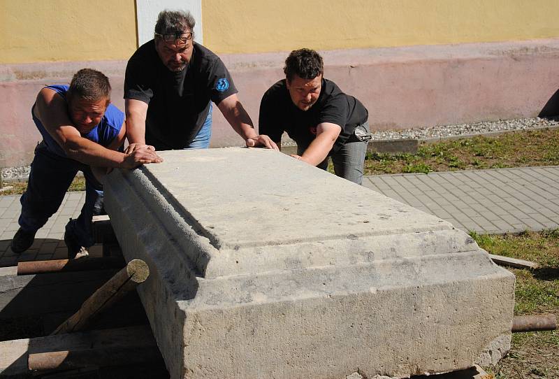 Ukládání cca 1 tunu vážícího náhrobního kamene na opravený hrob Aloise Mikyšky ve Veselé. Akci bylo nutné provést ručně, bez použití jeřábu, protože nad místem procházejí dráty elektrického vedení; pondělí 7. května 2018