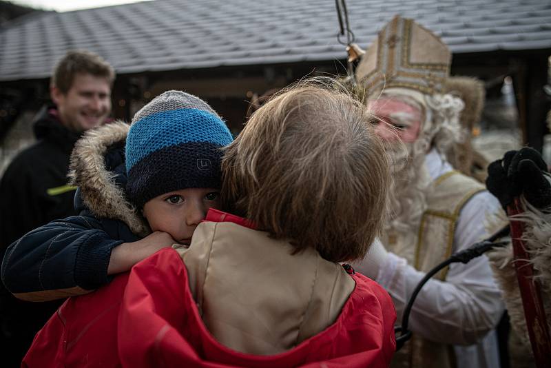 Muži v tradičních čertovských a mikulášských kostýmech procházejí při oslavě svátku sv. Mikuláše 4. prosince 2021 Valašskou Polankou.