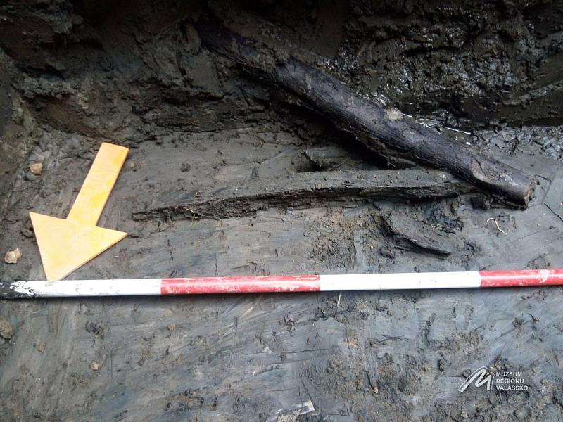 Archeologický průzkum v Kelči - Nález dřevěného kůlu s fragmentem desky. Artefakty byly nalezeny těsně nad dnem, v poslední vrstvě nad podložím.
