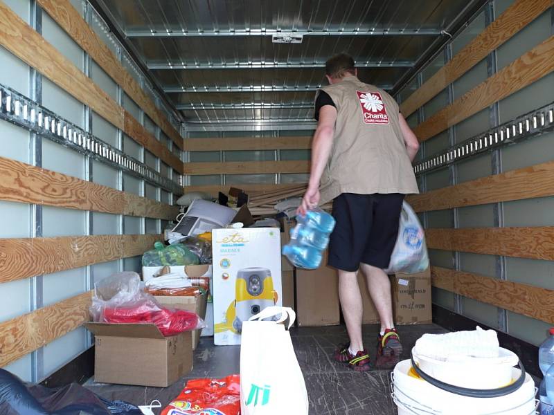Pracovníci valašskomeziříčské a olomoucké Charity nakládají čistící prostředky a další darované věci určené na pomoc lidem postiženým povodněmi; Valašské Meziříčí, pátek 14. června 2013. 
