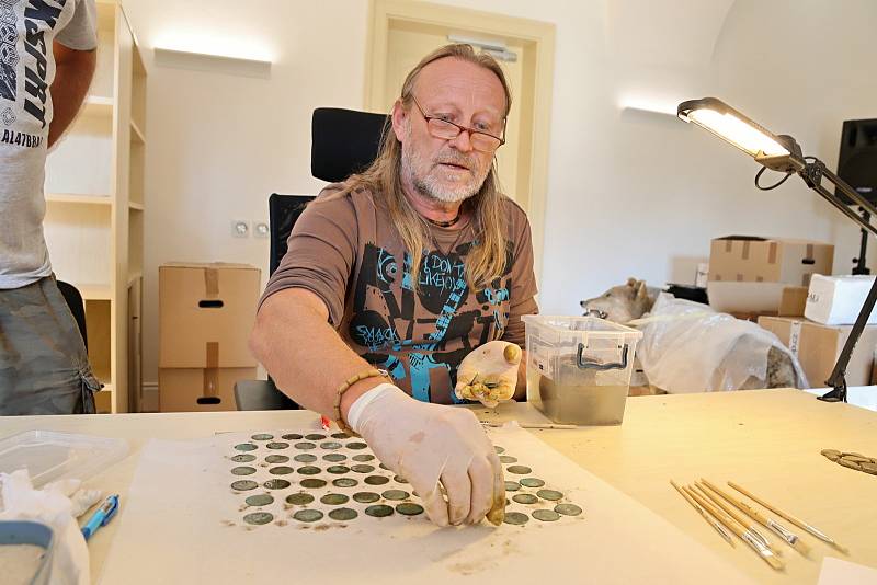 Konzervátor Muzea regionu Valašsko Zdeněk Hanáček zkoumá nález několika stovek stříbrných pražských grošů ze 14. století nalezených v lese v Ústí u Vsetína.