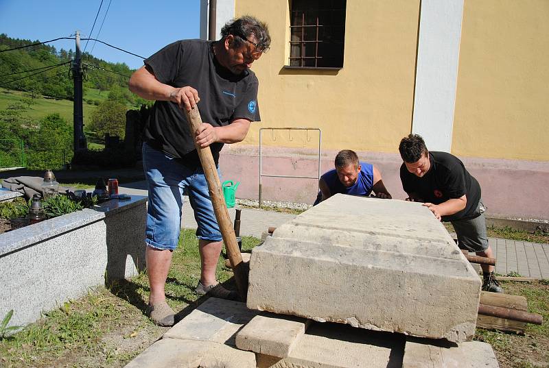 Ukládání cca 1 tunu vážícího náhrobního kamene na opravený hrob Aloise Mikyšky ve Veselé. Akci bylo nutné provést ručně, bez použití jeřábu, protože nad místem procházejí dráty elektrického vedení; pondělí 7. května 2018