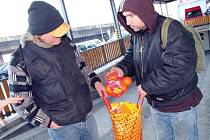 Mladí bezdomovci se deli o prošlé potraviny, vyřazené ze supermarketu.