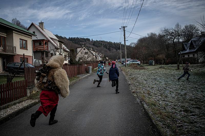 Muži v tradičních čertovských a mikulášských kostýmech procházejí při oslavě svátku sv. Mikuláše 4. prosince 2021 Valašskou Polankou.